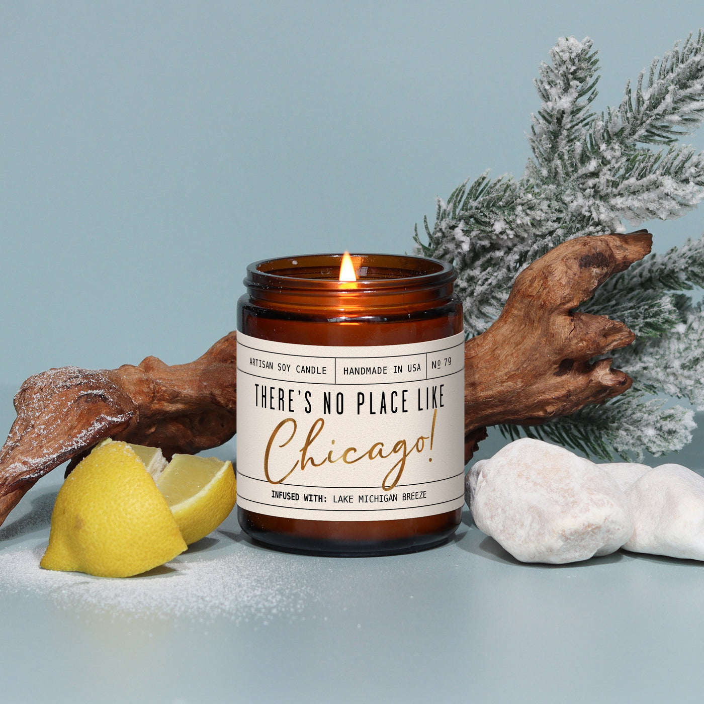 Candle with 'There's no place like Chicago' label, surrounded by decorative elements on a light blue background