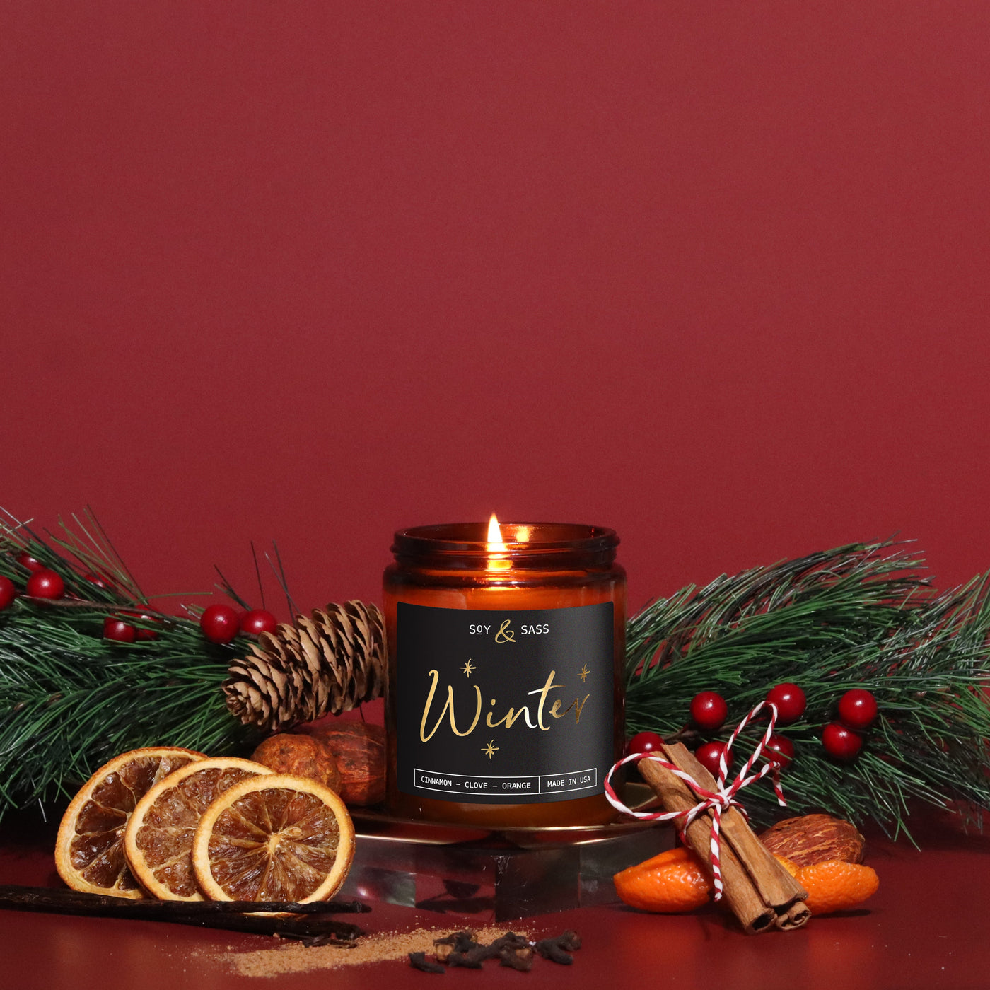 Candle labeled 'Winter' with decorative elements on a red background