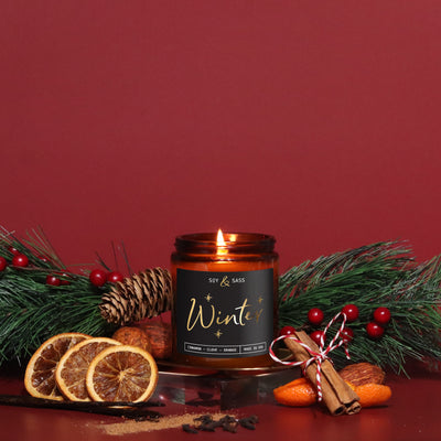 Candle labeled 'Winter' with decorative elements on a red background